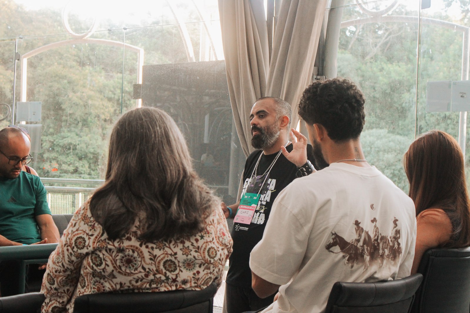 Chris Paes em uma conversa com participantes de um encontro